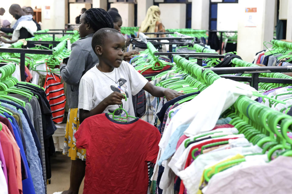 A child sifts through second hand clothes at Green Shop, a chain specializing in used clothes, in Kampala, Uganda, Friday, Sept. 15, 2023. Downtown Kampala’s Owino Market has long been a go-to enclave for rich and poor people alike looking for affordable but quality-made used clothes, underscoring perceptions that Western fashion is superior to what is made at home. But, despite their popularity, secondhand clothes are facing increasing pushback. (AP Photo/Hajarah Nalwadda)