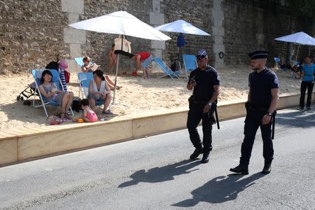 Policemen patrol during the opening day of the Paris Plages beach festival along the banks of River Seine in Paris, France, six days after a truck driver killed 84 people when he mowed through a crowd on the French Riviera, July 20, 2016. REUTERS/Charles Platiau