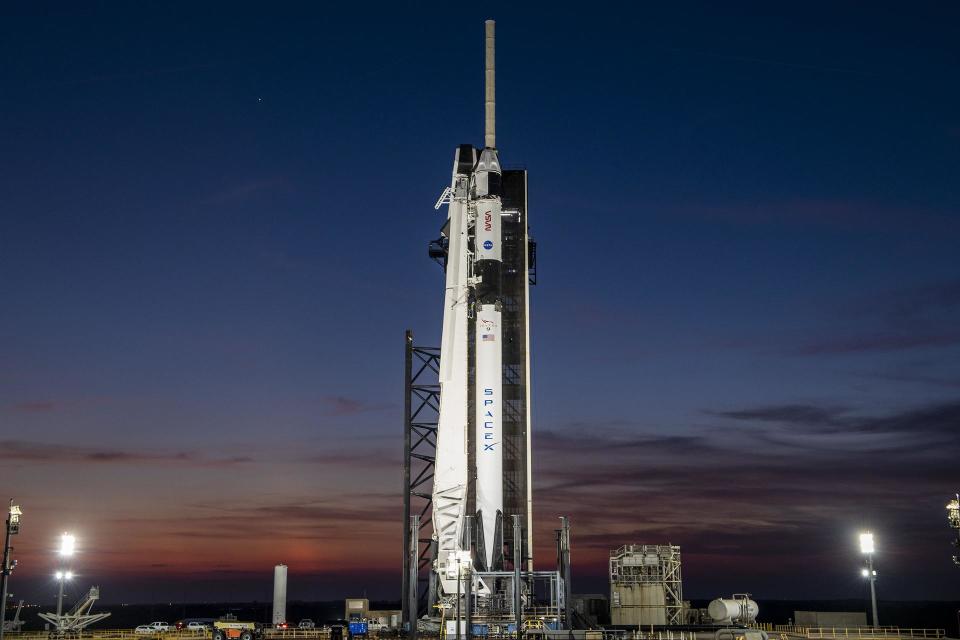 A colorful sunset serves as the backdrop for SpaceX's Falcon 9 rocket and Dragon spacecraft Endeavour on the pad at Launch Complex 39A at Kennedy Space Center in Florida.