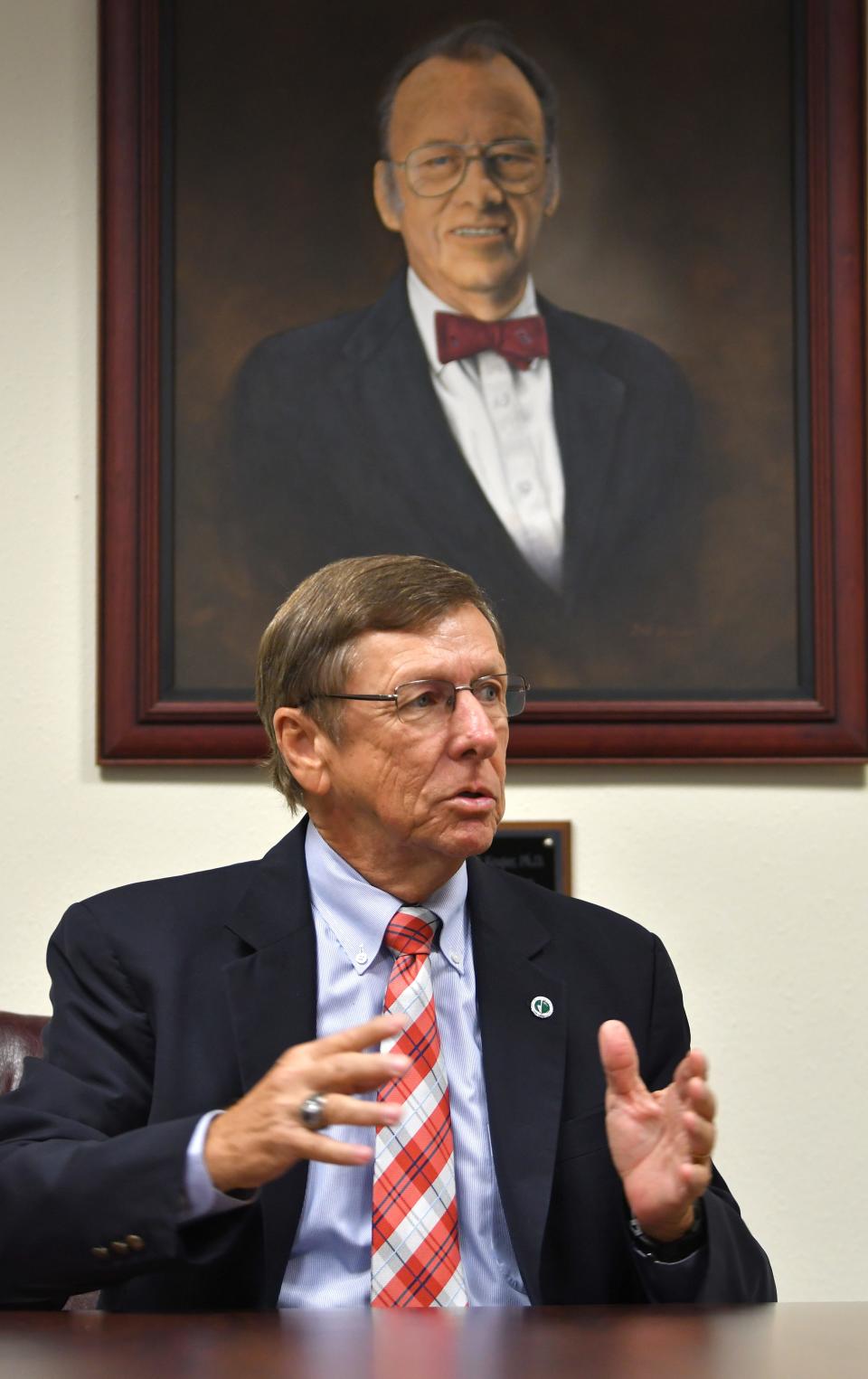 T. Dwayne McCay, former president of the Florida Institute of Technology, speaks alongside a portrait of university founder Jerome Keuper.