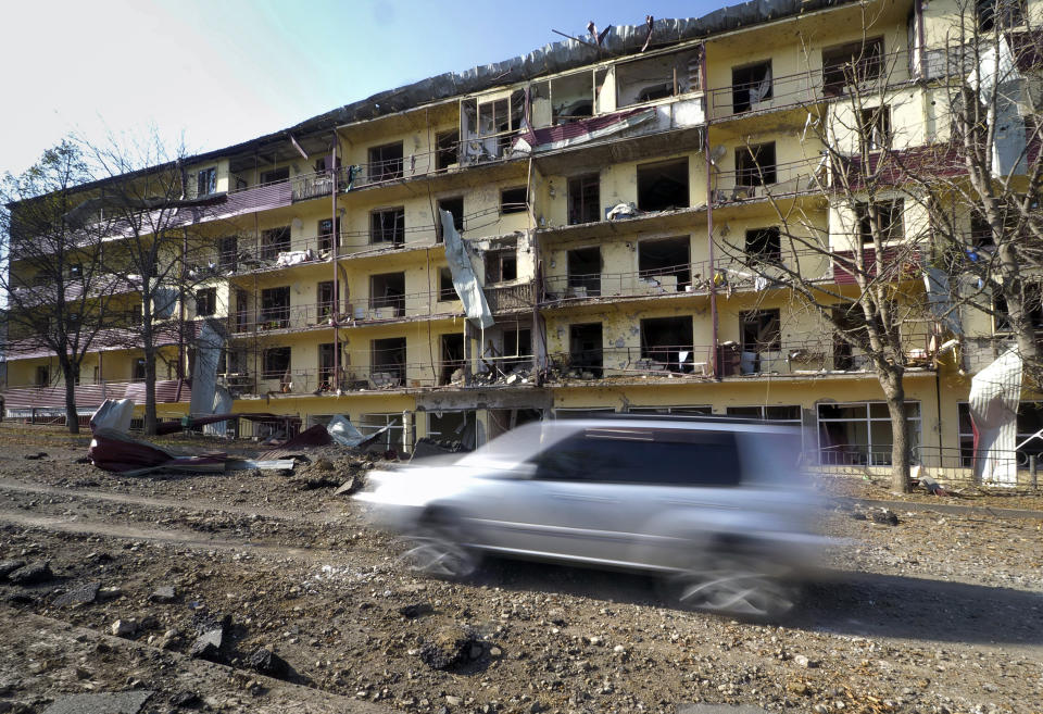 A car drives past an apartment building damaged by shelling by Azerbaijan's forces during a military conflict in Shushi, outside Stepanakert, the separatist region of Nagorno-Karabakh, Thursday, Oct. 29, 2020. Fighting over the separatist territory of Nagorno-Karabakh continued on Thursday, as the latest cease-fire agreement brokered by the U.S. failed to halt the flare-up of a decades-old conflict between Armenia and Azerbaijan. (AP Photo)