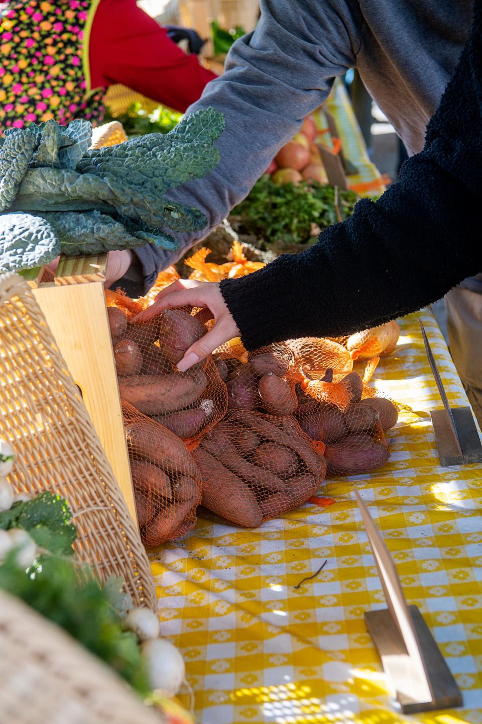 People look through produce offered at the Bounty & Soul Community Market in Black Mountain, Nov. 14, 2023.