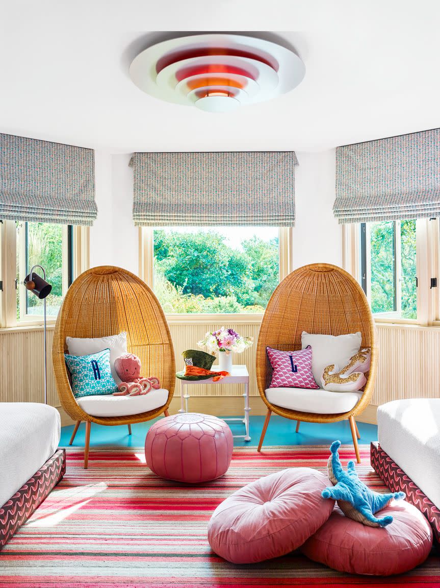 a room with a pink rug and chairs and a pink ball