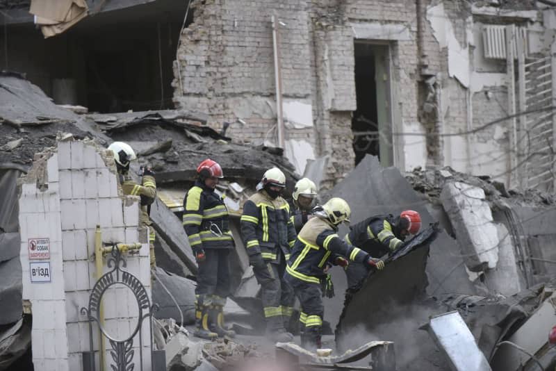 Rescuers search a destroyed building following a missile attack by the Russian army on Kiev. -/Ukrinform/dpa