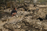 FILE - In this Sept. 11, 2020, file photo, Desiree Pierce cries as she visits her home destroyed by the Almeda Fire in Talent, Ore. "I just needed to see it, to get some closure," said Pierce. Two unusual weather phenomena combined to create some of the most destructive wildfires the West Coast states have seen in modern times. (AP Photo/John Locher, File)