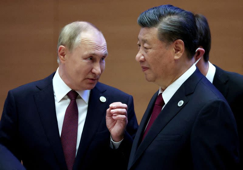 FILE PHOTO: Russian President Vladimir Putin speaks with Chinese President Xi Jinping