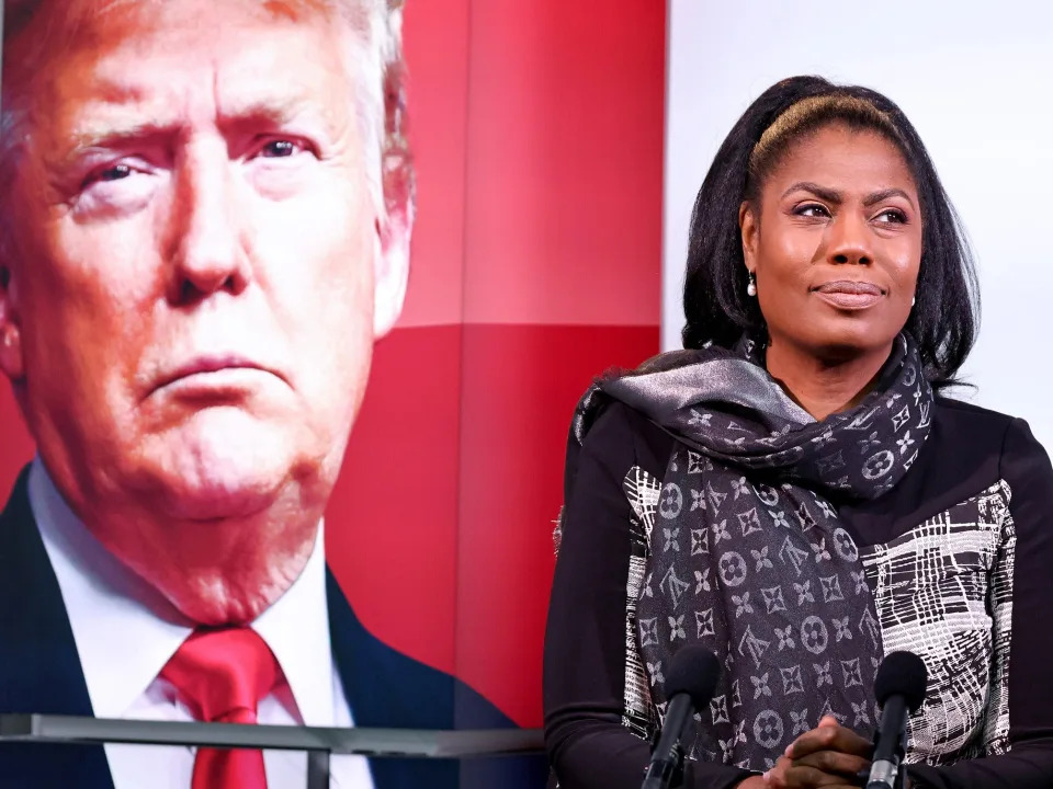 Omarosa Manigault Newman in front of an image of Trump