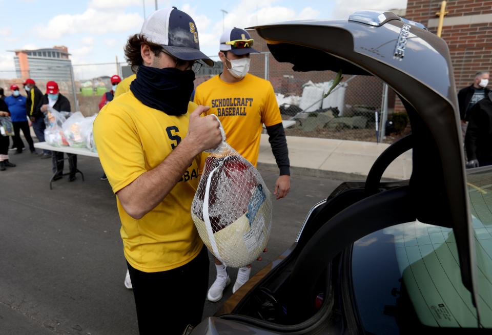 (Left) Tyler Garrett, 21 and a Schoolcraft College baseball player loads another car with frozen turkeys at The Corner Ballpark at Michigan and Trumbull in Detroit on Thursday, March 11, 2021.Meijer donated 1,000 turkeys to help families in need through a partnership with Detroit Police Athletic League (PAL).  The giveaway is one of several that will encompass more than $1 million (50,000 turkeys) of food relief for local food banks across the Midwest. 