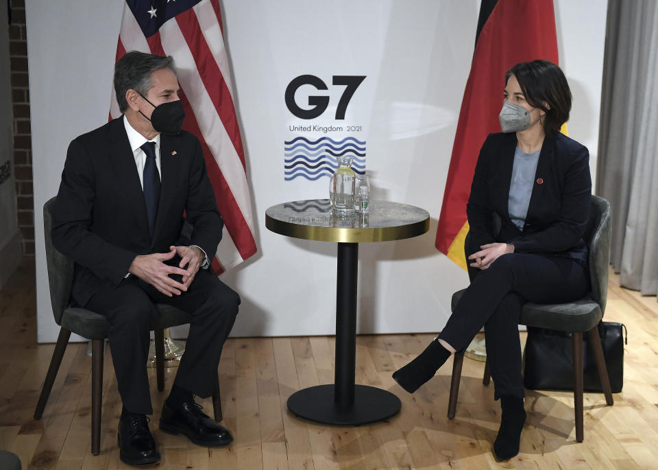 US Secretary of State Antony Blinken, left, and Germany's Foreign Minister Annalena Baerbock, wearing face coverings to combat the spread of the coronavirus, pose for a photograph before a bilateral meeting ahead of the G7 foreign ministers summit in Liverpool, England, Friday, Dec. 10, 2021. Blinken arrived in Britain for a G7 ministers' meeting before visiting Indonesia, Malaysia and Thailand. (Olivier Douliery/Pool Photo via AP)