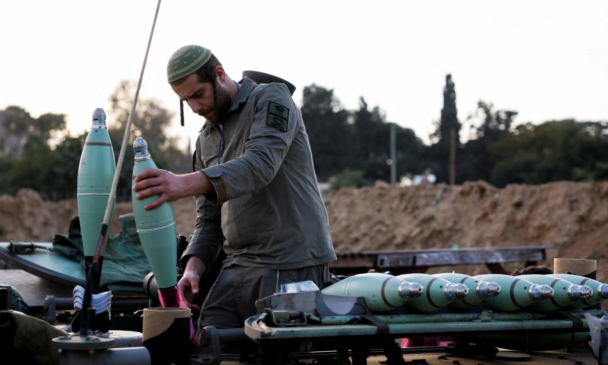 <span>An Israeli soldier prepares mortar shells before firing them as part of the offensive against Gaza.</span><span>Photograph: Amir Cohen/Reuters</span>