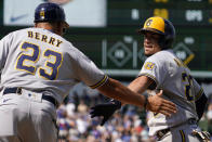 Milwaukee Brewers' Willy Adames, right, is congratulated by first base coach Quintin Berry after hitting a one-run single against the Chicago Cubs during the sixth inning of a baseball game in Chicago, Friday, Aug. 19, 2022. (AP Photo/Nam Y. Huh)