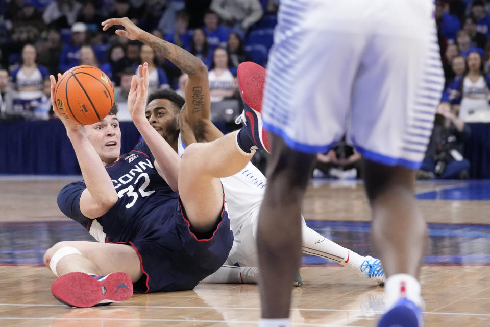 Connecticut's Donovan Clingan and DePaul's K.T. Raimey battle for a loose ball during the first half of an NCAA college basketball game Tuesday, Jan. 31, 2023, in Chicago. (AP Photo/Charles Rex Arbogast)