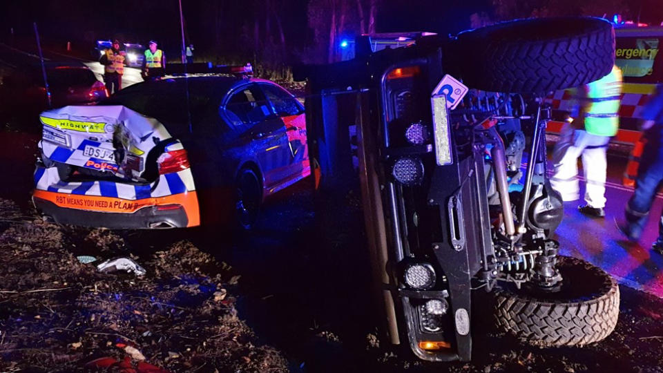 The parked police vehicle was hit by a 4WD from behind, which then rolled.