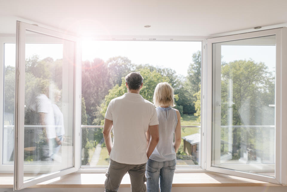 Mature couple looking out of window into the sun