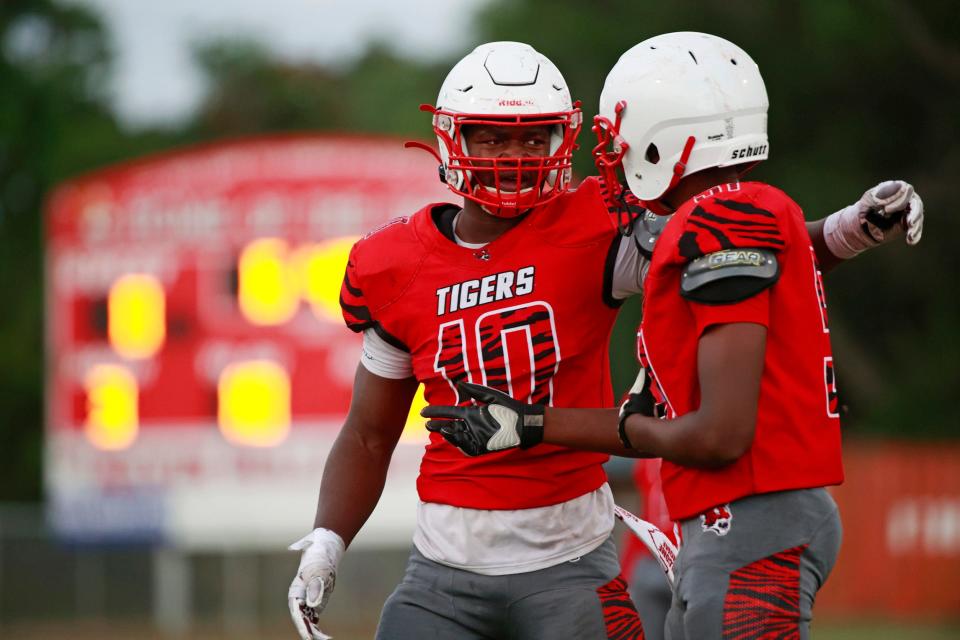 Andrew Jackson's Grayson Howard (10) talks with King Massey (51) during a scrimmage on May 20 at Andrew Jackson High School Stadium in Jacksonville.