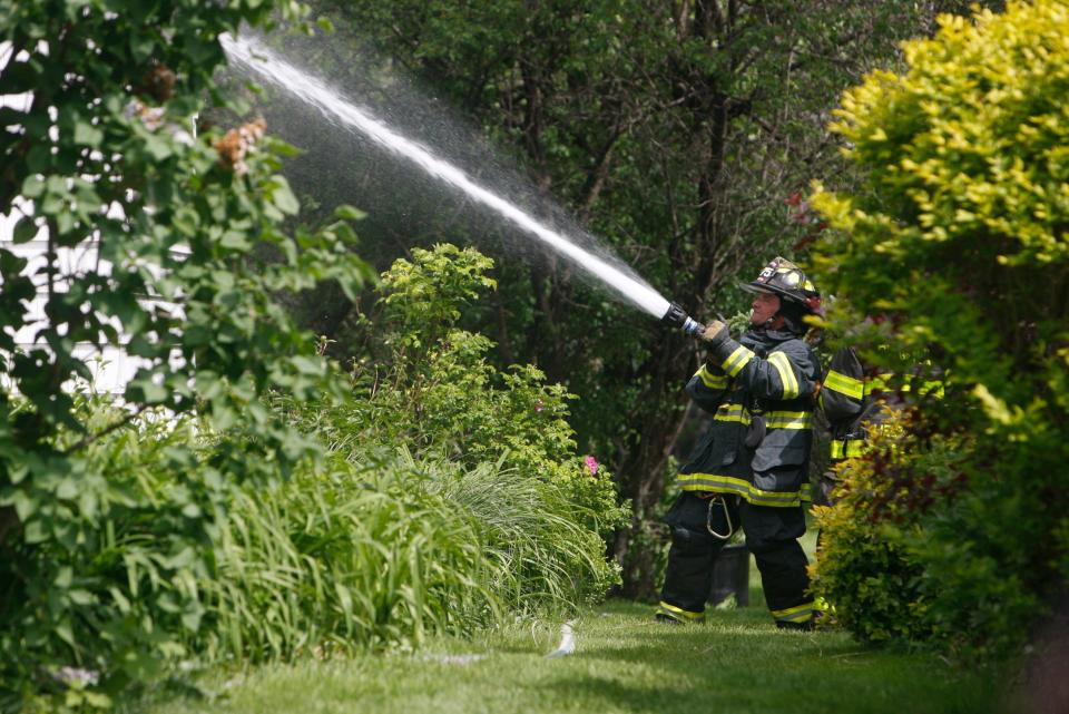 This 2015 file photo shows a Brighton firefighter putting out a fire on the back of a house on Eastland Drive in Brighton.