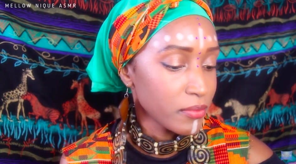 Role Play in Africa from Mellow Nique ASMR on YouTube. She is dressed in vibrant clothing