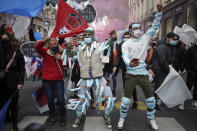 People wearing face masks on their body dance during a demonstration against the closure of the nightclubs, bars, shops and restaurants, in Lyon, central France, Monday, Nov. 23, 2020. France has surpassed 2 million confirmed cases of coronavirus, the fourth-highest total in the world. (AP Photo/Laurent Cipriani)