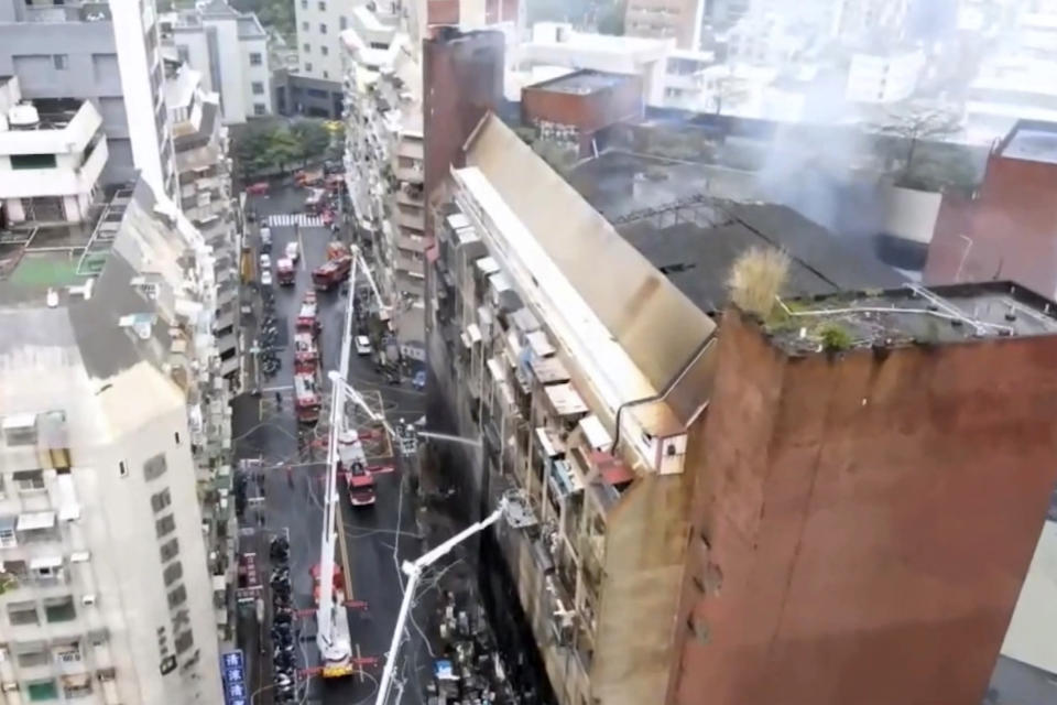 In this image taken from video by Taiwan's EBC, firefighters shoot water into a building that caught fire in Kaohsiung, in southern Taiwan on Thursday, Oct. 14, 2021. The fire engulfed a 13-story building overnight in southern Taiwan, the island's semi-official Central News Agency reported Thursday. (EBC via AP )