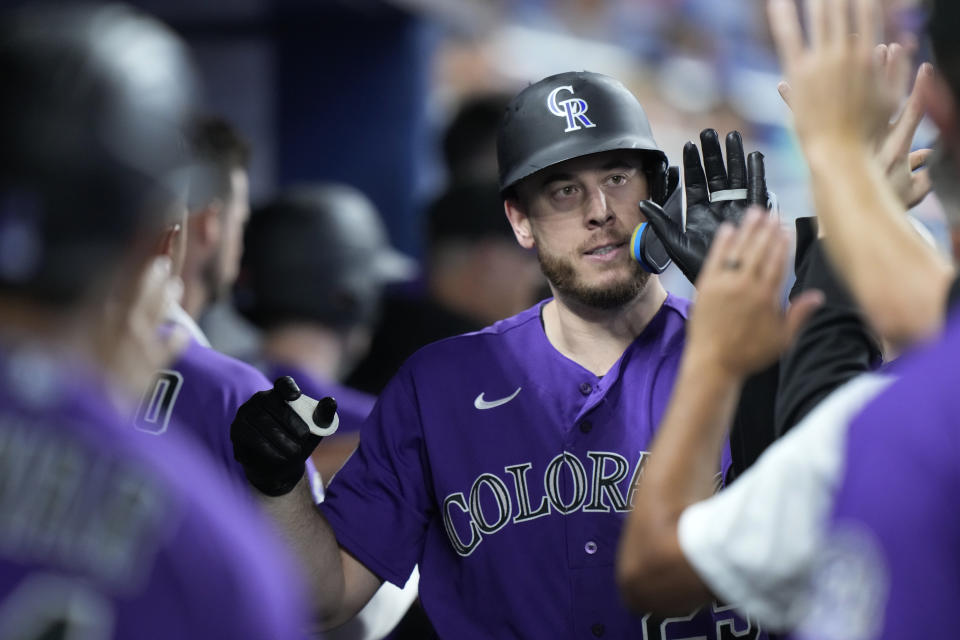 C.J. Cron de los Rockies de Colorado es felicitado por sus compañeros tras su jonrón que llevó a la anotación de Jurickson Profar en el encuentro ante los Marlins de Miami el viernes 21 de julio del 2023. (AP Foto/Wilfredo Lee)