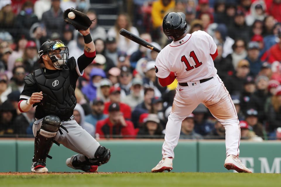Boston Red Sox's Rafael Devers (11) takes a high inside pitch in front of Chicago White Sox's Yasmani Grandal during the fifth inning of a baseball game, Saturday, May 7, 2022, in Boston. (AP Photo/Michael Dwyer)