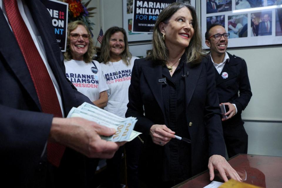 PHOTO: Democratic presidential candidate and author Marianne Williamson pays the US$1000 filing fee to put her name on the ballot for the primary election with New Hampshire Secretary of State David Scanlan in Concord, New Hampshire, October 12, 2023. (Brian Snyder/Reuters)
