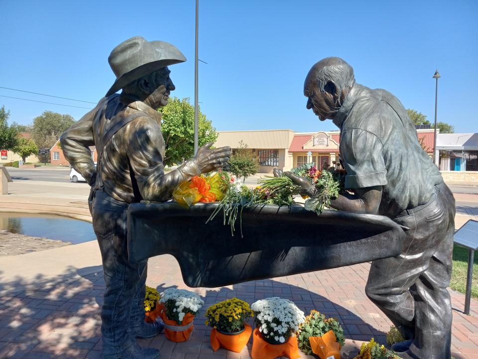 Flowers adorned "The Partnership" statue in downtown Artesia on Oct. 6, 2023. The statue honors the Marbob Energy company formed in 1972 by the late Johnny Gray and Mack Chase. Chase passed away Oct. 2, 2023.