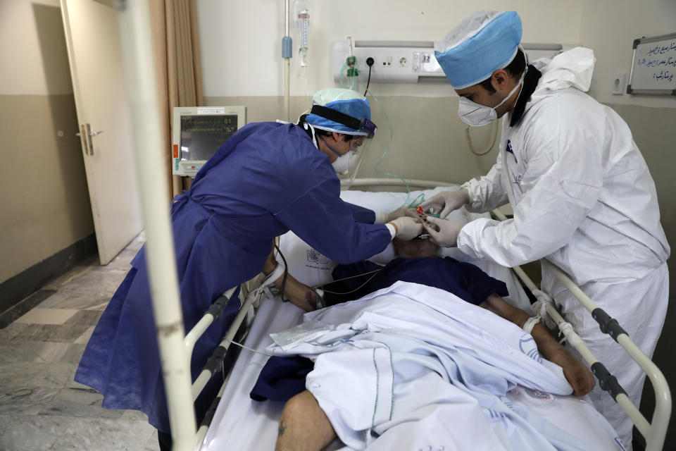 In this Tuesday, June 16, 2020, photo, medics tend to a COVID-19 patient at the Shohadaye Tajrish Hospital in Tehran, Iran. After months of fighting the coronavirus, Iran only just saw its highest single-day spike in reported cases after Eid al-Fitr, the holiday that celebrates the end of Ramadan. (AP Photo/Vahid Salemi)