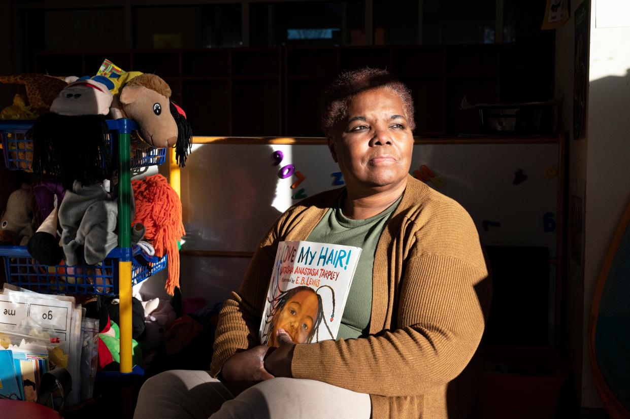 Priscilla Rowell, an early childhood educator at Excel Christian Academy in Burlington, NC sits on the rug of an empty class and holds one of her favorite books as the morning light shines through the classroom window Jan. 12, 22.