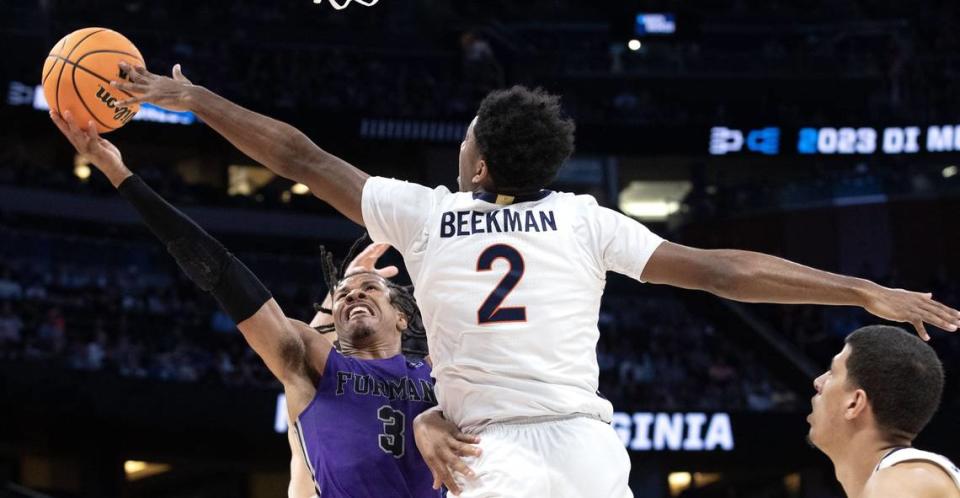 Furman’s Mike Bothwell (1) fights for the ball with Virginia’s Reece Beekman (2) during the first round of the NCAA tournament in Orlando.