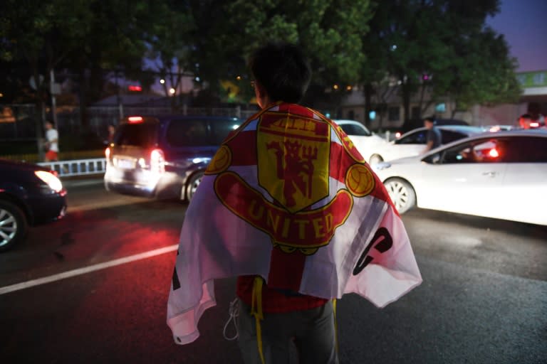 A Manchester United fan waits for the team bus after a training session, in Beijing on July 24, 2016