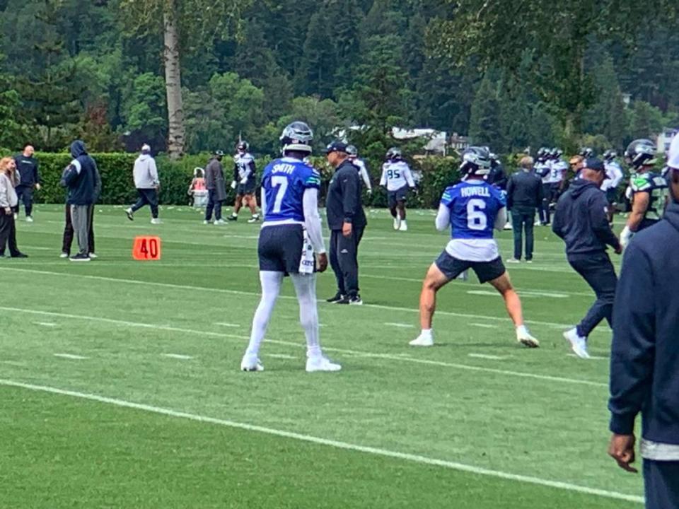 Backup quarterback Sam Howell (6) throws while starter Geno Smith (7) watches as they alternate in drills during the second of 10 NFL organized team activities (OTAs) practices for the Seattle Seahawks at team headquarters in Renton May 23, 2024.