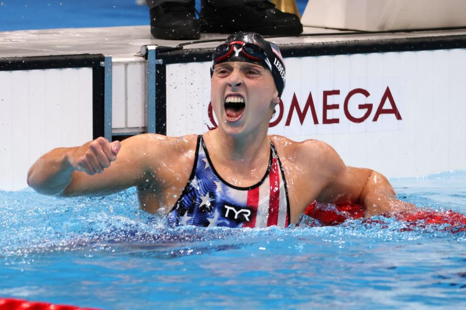 Katie Ledecky raises a fist and shouts from the pool at the Tokyo Olympics.