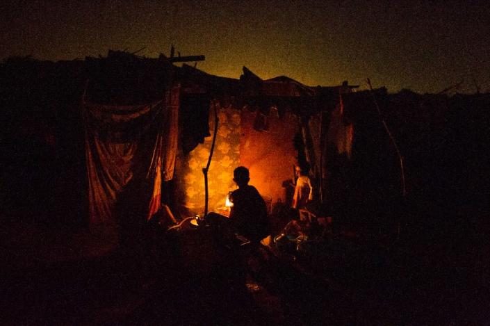 A woman cooks in a tent in the refugee camp at M'Poko airport, in Bangui, Central African Republic, on February 22, 2014 (AFP Photo/Fred Dufour)
