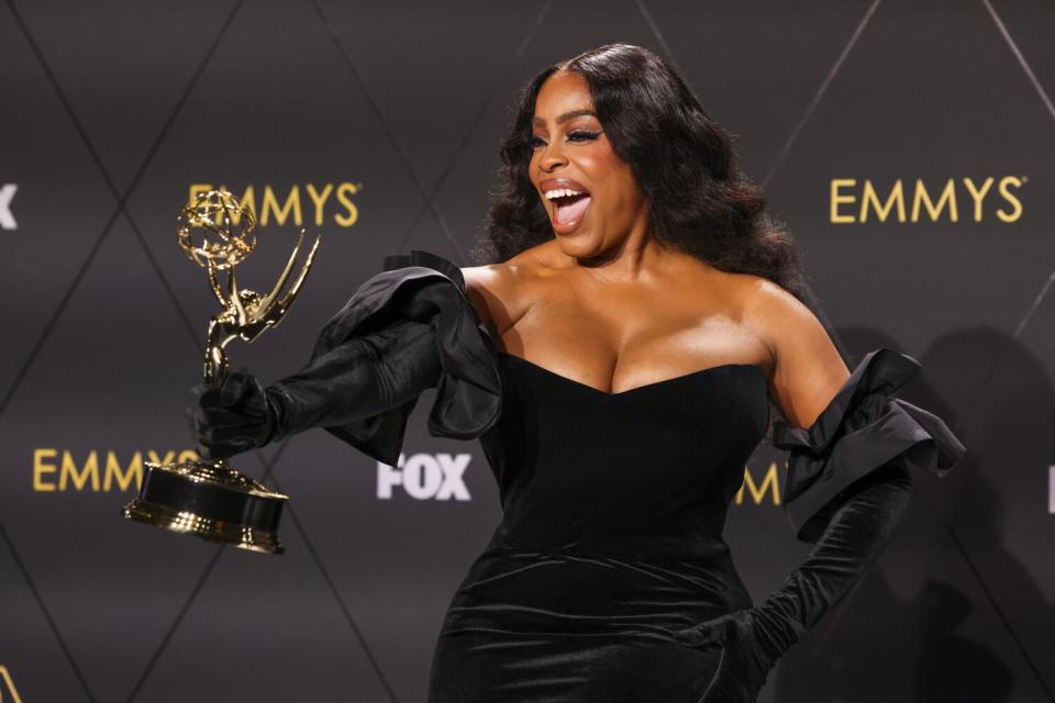 An actor holds an Emmy Award.