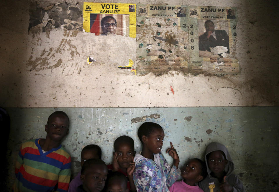 <p>Children stand beneath posters from the 2008 Zanu Pf election campaign in the Mbara suburb of Harare, Zimbabwe, Friday. Nov. 17, 2017. (Photo: AP) </p>