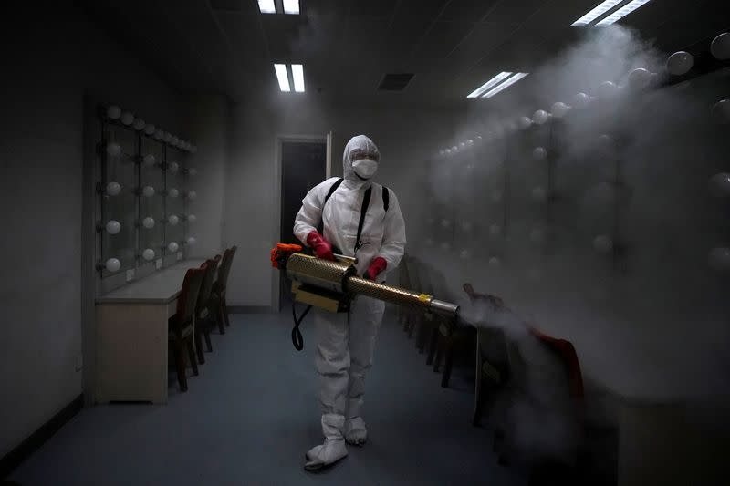 A volunteer from the Blue Sky Rescue team disinfects at the Qintai Grand Theatre in Wuhan