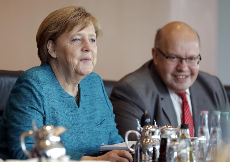 German Chancellor Angela Merkel, left, and Peter Altmaier, Head of the Federal Chancellery and Federal Minister for Special Tasks, right, attend the weekly cabinet meeting at the Chancellery in Berlin, Germany, Wednesday, April 12, 2017. (AP Photo/Michael Sohn)