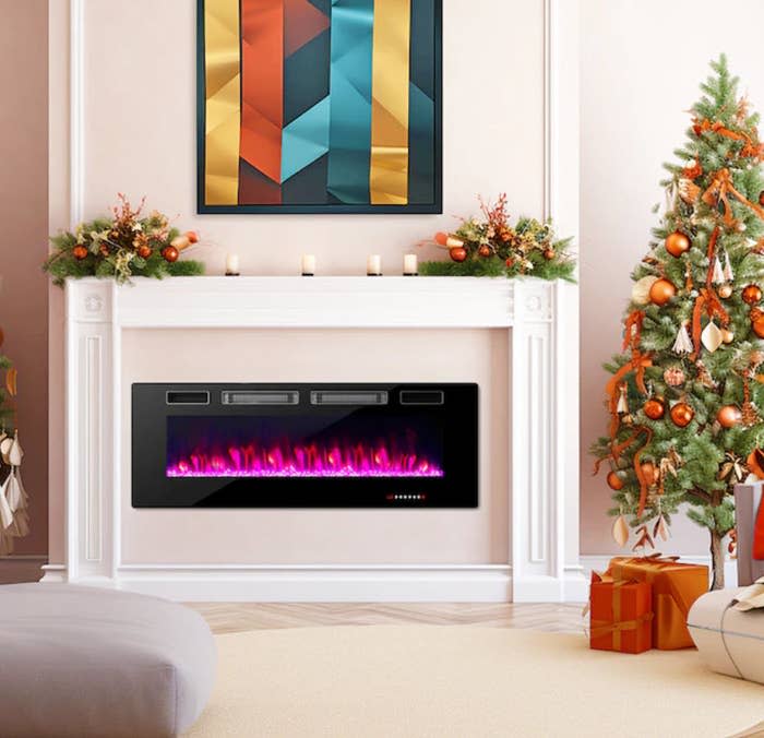 electric fireplace with pink flames in living room with holiday decor