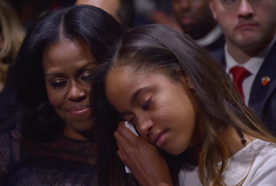 Michelle Obama holds her daughter Malia during President Obama's farewell address.