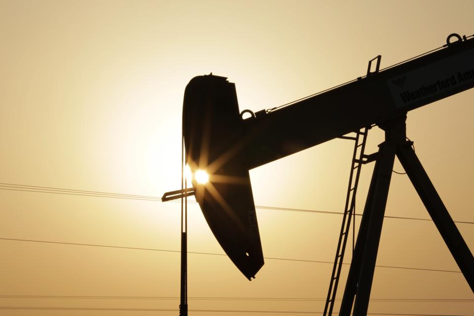 FILE- In this Wednesday, Sept. 30, 2015 file photo, an oil pump works at sunset in the desert oil fields of Sakhir, Bahrain. A U.N.-backed study has found that the world needs to cut by more than half its production of coal, oil and gas in the coming decade to maintain a chance of keeping global warming from reaching dangerous levels. The report published Wednesday, Oct. 20, 2021 by the U.N. Environment Program noted that many governments have made ambitious pledges to curb greenhouse gas emissions. But it found they are still planning to extract double the amount of fossil fuels in 2030 than what would be consistent with the goal of keeping global temperature rise below 1.5 degrees Celsius (2.7 degrees Fahrenheit). (AP Photo/Hasan Jamali, file)