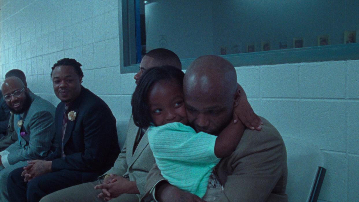 An incarcerated dad gives his kid a big hug at a prisoner father-daughter dance in the documentary "Daughters."