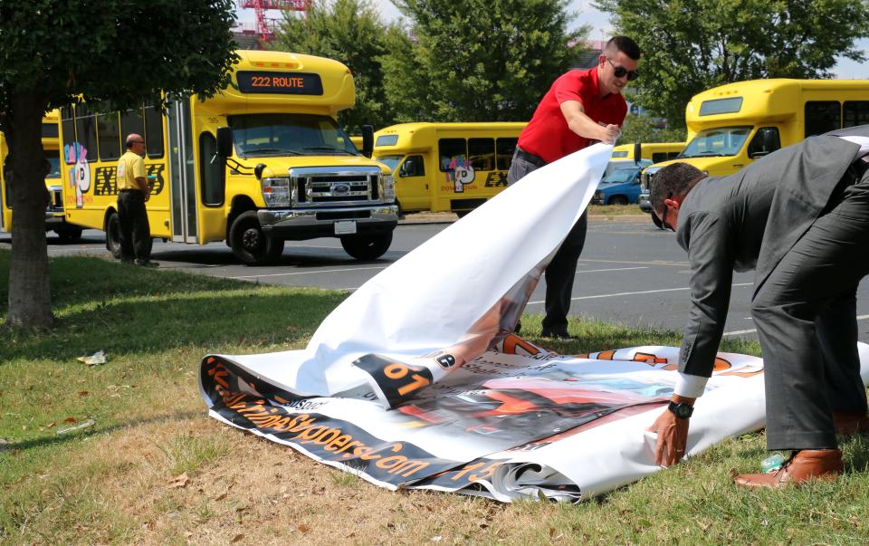 Zach Shelton and Metro Nashville Police Department Sgt. Brian Brown unfurl a banner on Sept. 13, 2019, with the hopes of finding a suspect in the killing of Joe Shelton Jr.