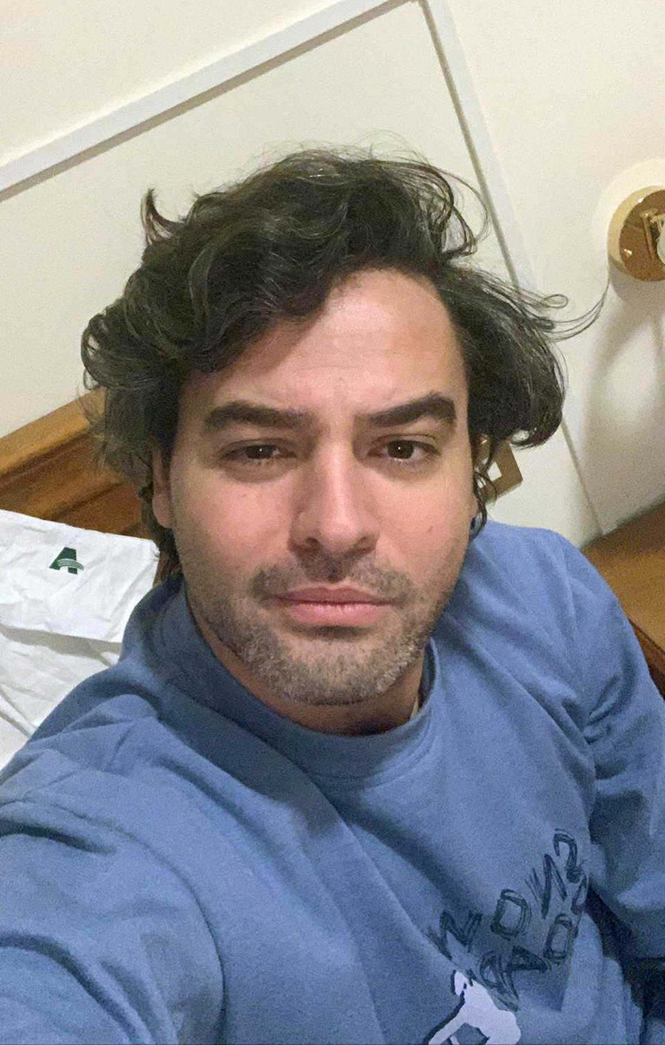 Andrea Napoli, 33, takes a selfie in a hotel being used for patients recovering from coronavirus, in Rome, Sunday, March 29, 2020. Andrea Napoli, a lawyer in Rome, developed a cough and fever less than a week after Italy&#39;s premier locked down the entire nation, including the capital which had continued life as usual while the virus raged in the north. He received a positive diagnosis for COVID-19 three days later. Initially, Napoli was told to quarantine at home with the warning that his condition could deteriorate suddenly, and it did. By the next day, he was hospitalized in intensive care, with X-rays confirming he had developed pneumonia. (Andrea Napoli via AP)