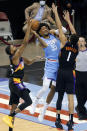 Houston Rockets center Christian Wood (35) shoots between Phoenix Suns forward Mikal Bridges, left, and guard Devin Booker (1) during the second half of an NBA basketball game Wednesday, Jan. 20, 2021, in Houston. (AP Photo/Michael Wyke)