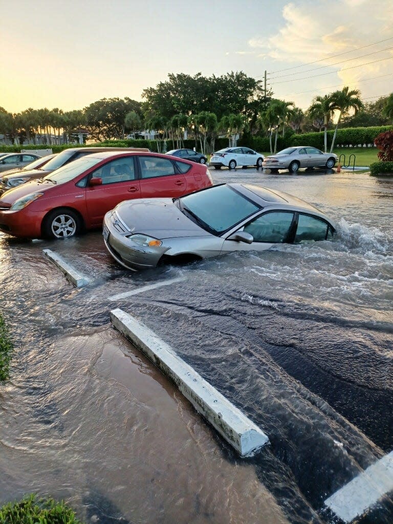 Ingrid Robinson's 2002 Honda Civic falls into a sinkhole Saturday morning caused by a water main break at the KIngs Point community west of Delray Beach.