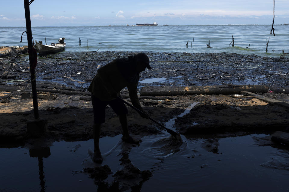 Un hombre retira agua sucia del interior de una choza de paja instalada en la orilla del Lago de Maracaibo contaminado con basura y derrames de petróleo, en San Francisco, Venezuela, el jueves 10 de agosto de 2023. La contaminación en torno al lago, uno de los más grandes de América Latina, es resultado de décadas de excesiva explotación petrolera en su lecho, mantenimiento inadecuado y falta de inversión en una infraestructura obsoleta, según ambientalistas. (AP Foto/Ariana Cubillos)