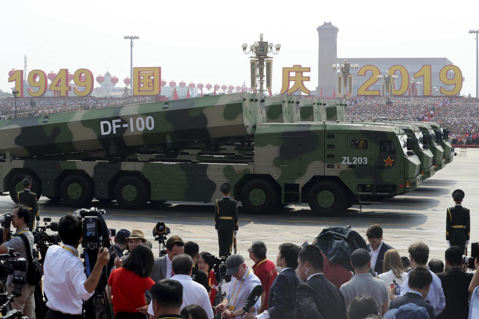 Military vehicles carrying DF-100 roll down as members of a Chinese military honor guard march during the celebration to commemorate the 70th anniversary of the founding of Communist China in Beijing, Tuesday, Oct. 1, 2019. (AP Photo/Ng Han Guan)