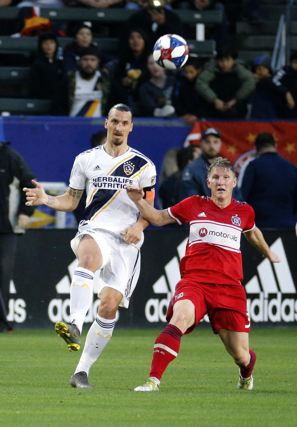 LA Galaxy forawrd Zlatan Ibrahimovic, left, of Sweden, kicks the ball away from Chicago Fire midfielder Bastian Schweinsteiger of Germany in the first half of an MLS soccer match in Carson, Calif., Saturday, March 2, 2019. (AP Photo/Ringo H.W. Chiu)