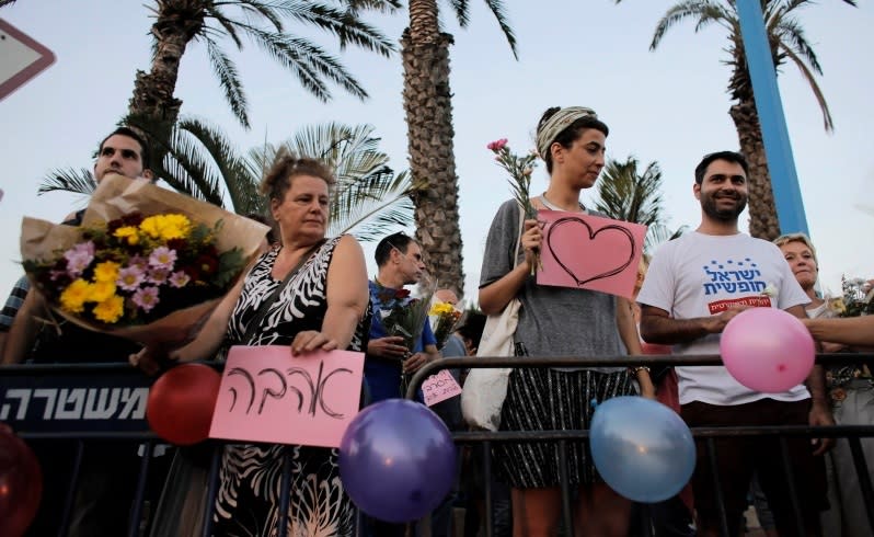 Protesters hold signs in support of the wedding of groom Mahmoud Mansour, 26, and bride Maral Malka, 23, outside a wedding hall in Rishon Lezion, near Tel Aviv August 17, 2014. Israeli police on Sunday blocked more than 200 far-right Israeli protesters from rushing guests at the wedding of a Jewish woman and Muslim man as they shouted "death to the Arabs" in a sign of tensions stoked by the Gaza war. Picture taken August 17, 2014. To match MIDEAST-ISRAEL/WEDDING REUTERS/Ammar Awad